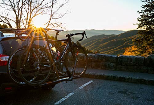 Bicycles on a car rack with a sunset mountain view.