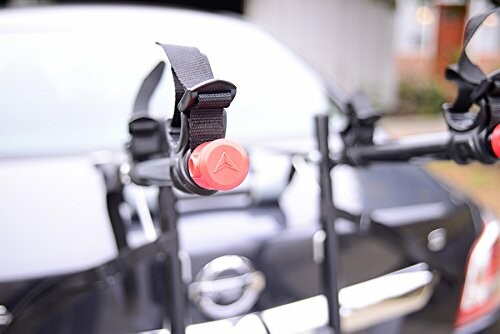 Close-up of a car bike rack with straps and red fasteners.