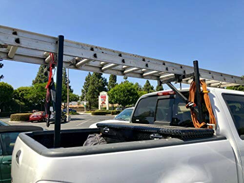 Ladder secured on a pickup truck bed in a parking lot.