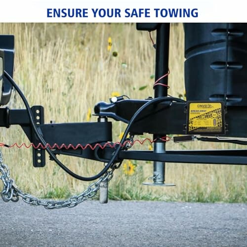 Close-up of a trailer hitch with safety chains and attachments