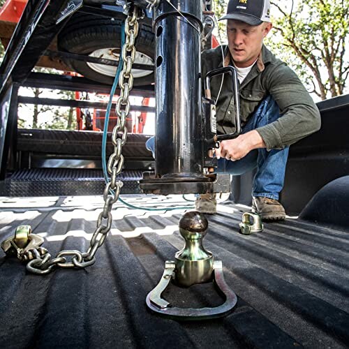 Man installing a trailer hitch in a truck bed.