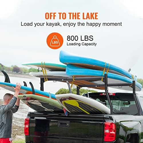 Truck loaded with surfboards near a lake.