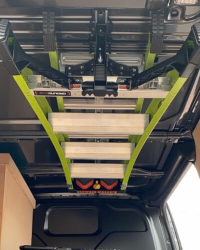 Ceiling-mounted ladder storage in a van.